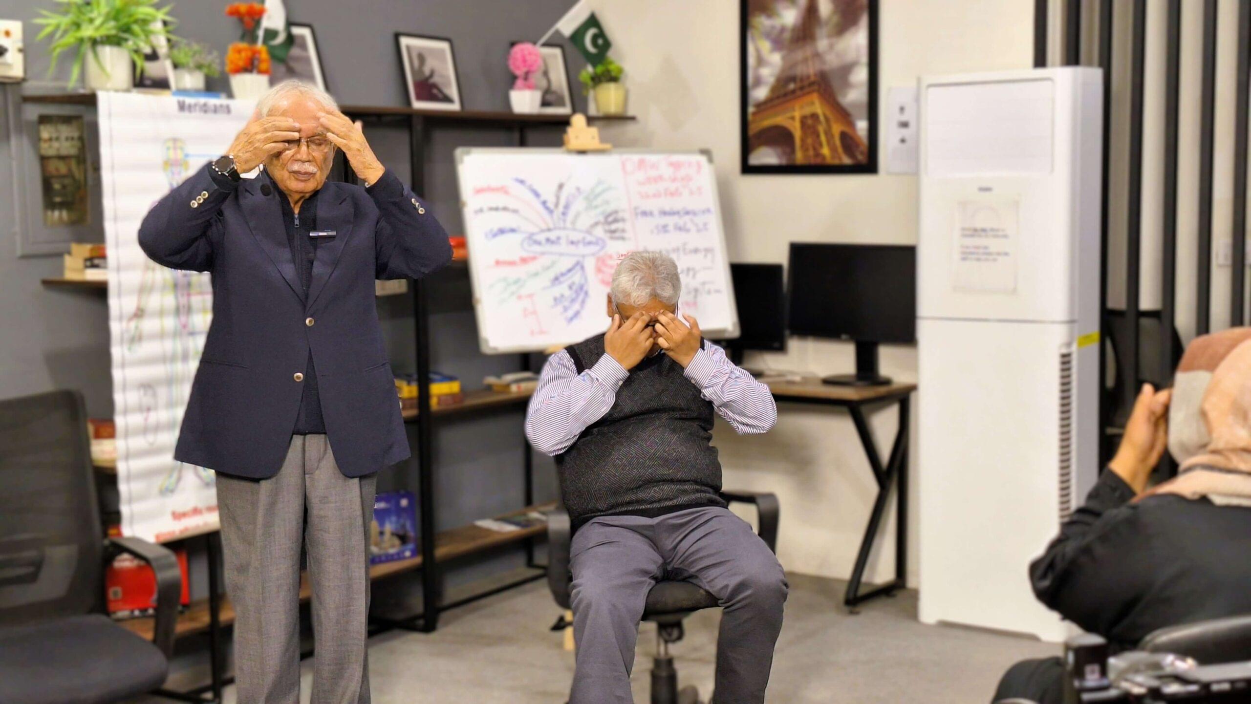 a person along with dr imtiaz mehmud practicing omw energy tapping